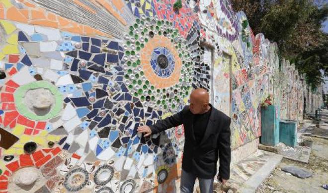 Syrian-artist-Moaffak-Makhoul-poses-near-his-decorated-wall-after-it-won-the-guinness-world-