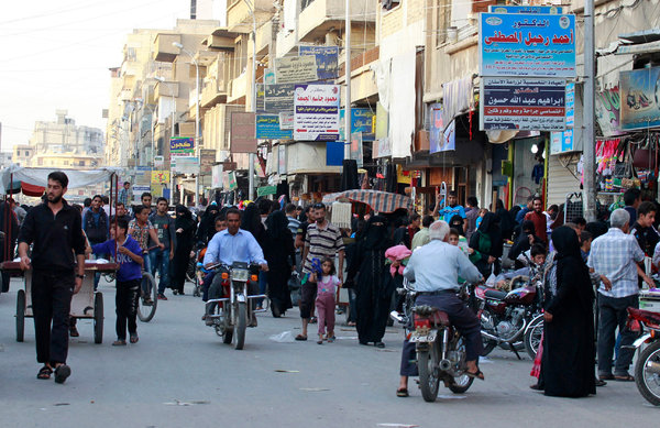 ISIS 15isiswomen-web5-articleLargeThe Tal Abyad street market last year, before the Eid al-Adha festival. Credit Reuters